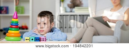 Child looking at colorful toy pyramid during a therapy session