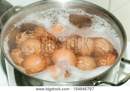 Cooking eggs in boiling water, in shiny metal pots. Domestic kitchen. Boiled eggs.