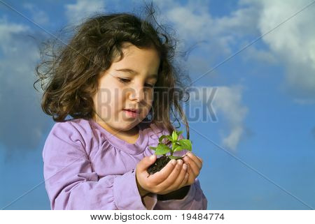Little girl gazdaság növény, kék ég, a felhők ellen