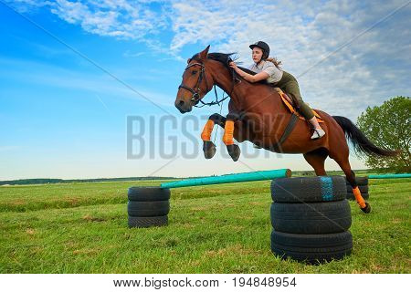 Pretty young girl jockey and her horse jumper