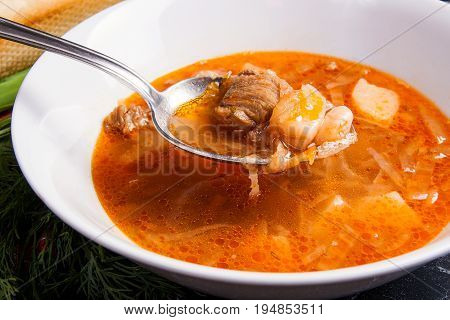 Close Up View Of Plate And Spoon With Red Beetroot Soup Or Borsch On Dark Marble Background. .