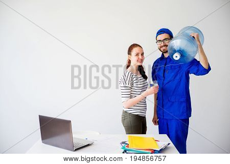Water delivery into an office: a guy in blue shirt brings a canister