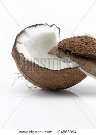 A Coconut cut in Two Pieces on a White Background