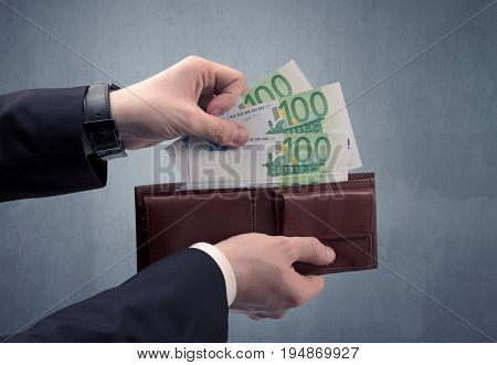 Businessman's hand in suit takes out eruo from his wallet
