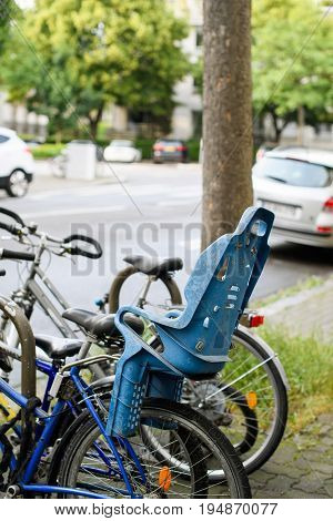 Modern bicycle with blue security confort kid child seat behind in city environemnt