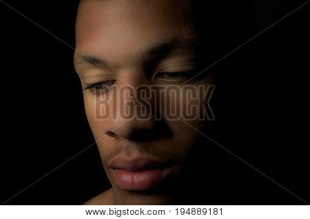 Young man in a low key photo looking serious