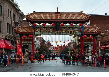Victoria BC,Canada,January 27th 2017.The gates of Harmonius Interest guard Canada's oldest Chinatown in Victoria BC.People enjoying Chinese New Year in Victoria's Chinatown.