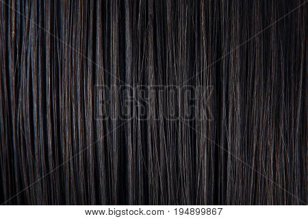 Straight black hair close-up. Texture of dark woman hair. Black female hair background.