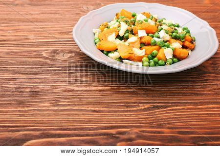 Warm salad with roasted pumpkin, peas and cheese brie. Low fat healthy eating concept.