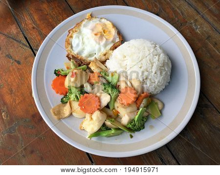 Mixed Fried Vegetable Tofu With Rice And Fried Egg In White Dish On Wooden Background. Vegetarian Fo