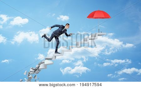 A businessman running up on crumbling concrete steps through the clouds to reach a red umbrella. Business protection. Hostile market environment. Survival strategy.