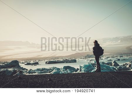 Woman explorer lookig at Jokulsarlon lagoon, Iceland.