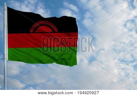 National flag of Malawi on a flagpole in front of blue sky.