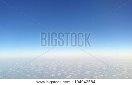 Cirrocumulus (small patched) cloud under blue sky separated by the horizon, topview from airplane window-natural background; concepts of freedom, peaceful, heaven, separate; top copyspace