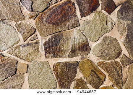 Texture of a surface from a multicolored wet sandstone of different sizes for use as background.
