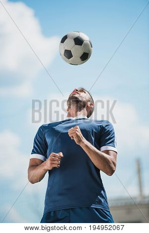 Low Angle View Of Soccer Player Training With Ball On Soccer Pitch