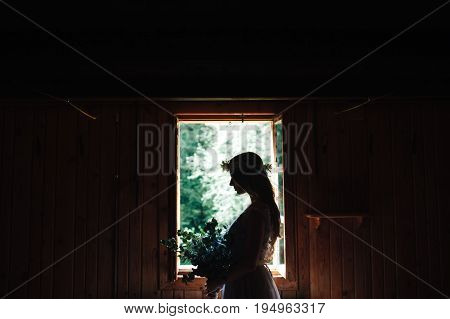 the silhouette of the bride in the window