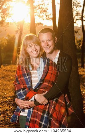 young loving couple standing hugging in the woods