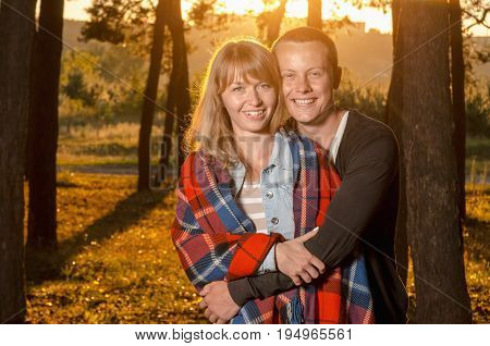 young loving couple standing hugging in the woods