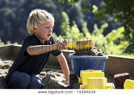 Mladík nabírání písek na autíčko v karanténě.
