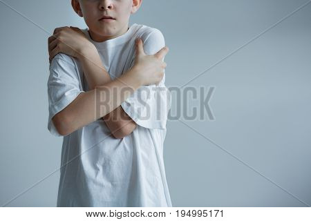 Scared boy in white t-shirt - conceptual photo