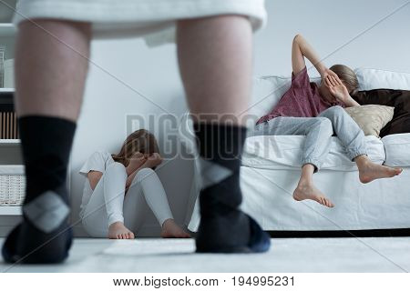 Terrified children hiding from their aggressive father