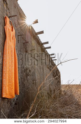 Orange Dress With Gold Thread On The Falling Down Wall