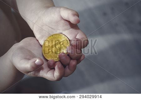 Bitcoin Concept. Children Share Bitcoin. Child Hand And Bitcoin.
