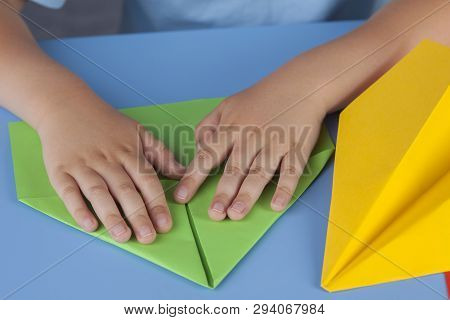 Child Making A Paper Plane. Close Up.