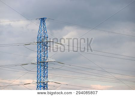 High Voltage Power Line Post With Electrical Wires And Capacitors On Cloudy Sky Background. Electric