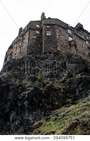 A Dramatic View Of A Sunlit Edinburgh Castle With Heavy Clouds Above