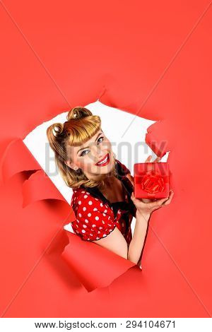 Smiling Retro Woman Hold Gift Box Through Hole In Paper. Beautiful Blonde Woman In Polka-dot Dress. 