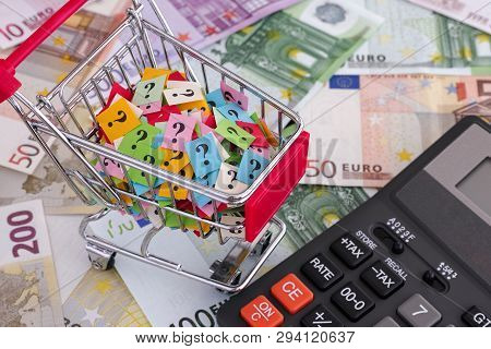 Euro Banknotes, Shopping Cart With Question Marks And Calculator. Close Up.
