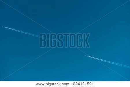 Two Airplane With White Condensation Tracks. Jet Plane On Clear Blue Sky With Vapor Trail. Travel By