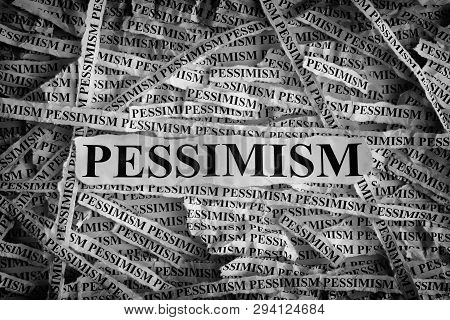 Pessimism. Torn Pieces Of Paper With The Word Pessimism. Concept Image. Black And White. Closeup.