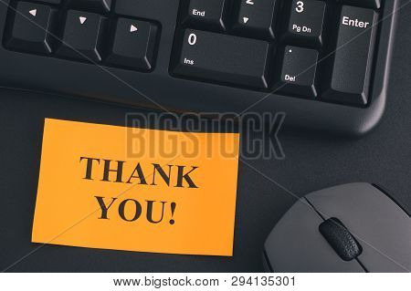 Thank You!. Paper Note With Writing Thank You! On A Desk With Black Keyboard And Grey Wireless Mouse