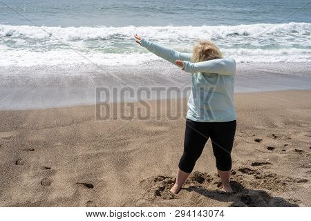 Blonde Woman Does A Dabbing Dance Move On The Beach