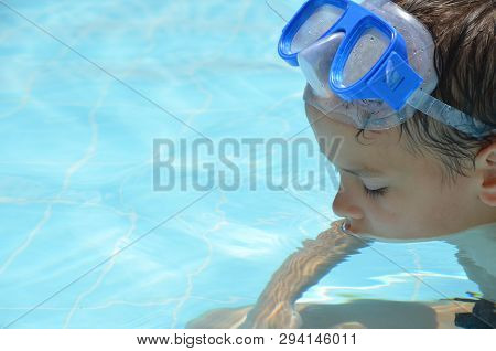 Teenager Boy Wearing Mask Swimming In The Pool. Happy Holiday Concept. Cute Happy Little Boy Swimmin