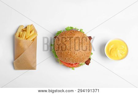 Tasty Burger, French Fries And Sauce On White Background, Top View