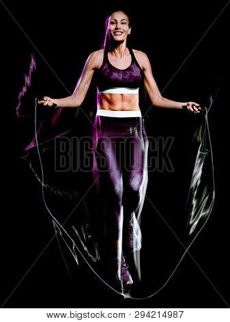 one beautiful caucasian mixed race woman exercising  jumping rope fitness exercises in studio isolated on black background