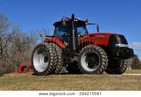 Moorhead, Minnesota, March 7, 2019:  The Huge Red 240 Magnum Tractor Pumping Water At A Lift Station