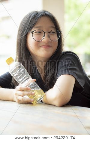 Asian Teenager Smiling Face Holding Pastic Bottle In Hand