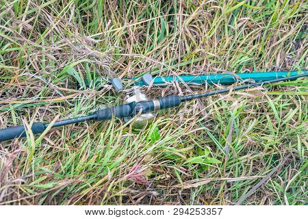 Spinning Rod With Baitcasting Reel On The Grass. Selective Focus
