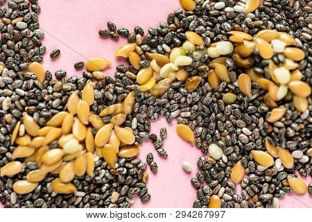 Healthy superfood:  flax seeds, chia seeds and hemp shelled seed on pink background