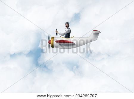 Happy Pilot Driving Small Propeller Plane On Background Of Blue Sky With Clouds. Traveling Around Th