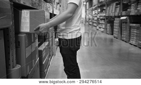 Warehouse Large Storage Or Logistic Or Cargo For Distribution. And Man's Hand Is Picking Up A Box.