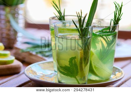 Three Glasses With Atural  Lemonade Made From  Lemon Rosemary And Mint In Glasses On Wooden Table At