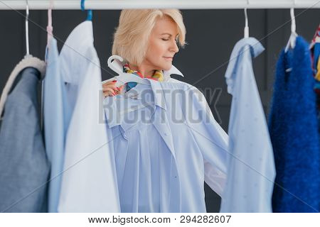 Senior Business Lady. Modern Woman Lifestyle. Aged Fashion Trendsetter At Showroom Choosing Outfit F