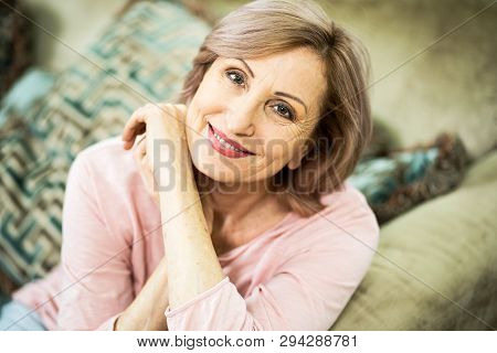 Woman Of European Appearance Resting At Home In The Living Room. In Appearance Woman Are Over 50 Yea