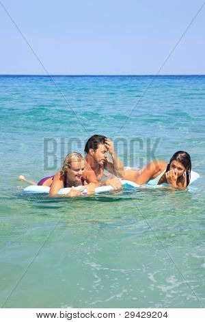 Gruppo di tre amici - uomo e donna - sulla spiaggia avendo un sacco di divertimento in vacanza in Grecia